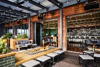 Rooftop bar with heated, covered seating and shuffleboard