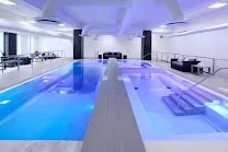 Indoor glass-bottom pool with sauna and hot tub